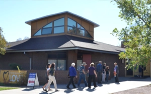 Congregants walk towards the front doors of our building from outside.